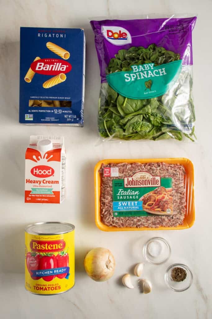 Ingredients to make One Pot Sausage Rigatoni on a tabletop.