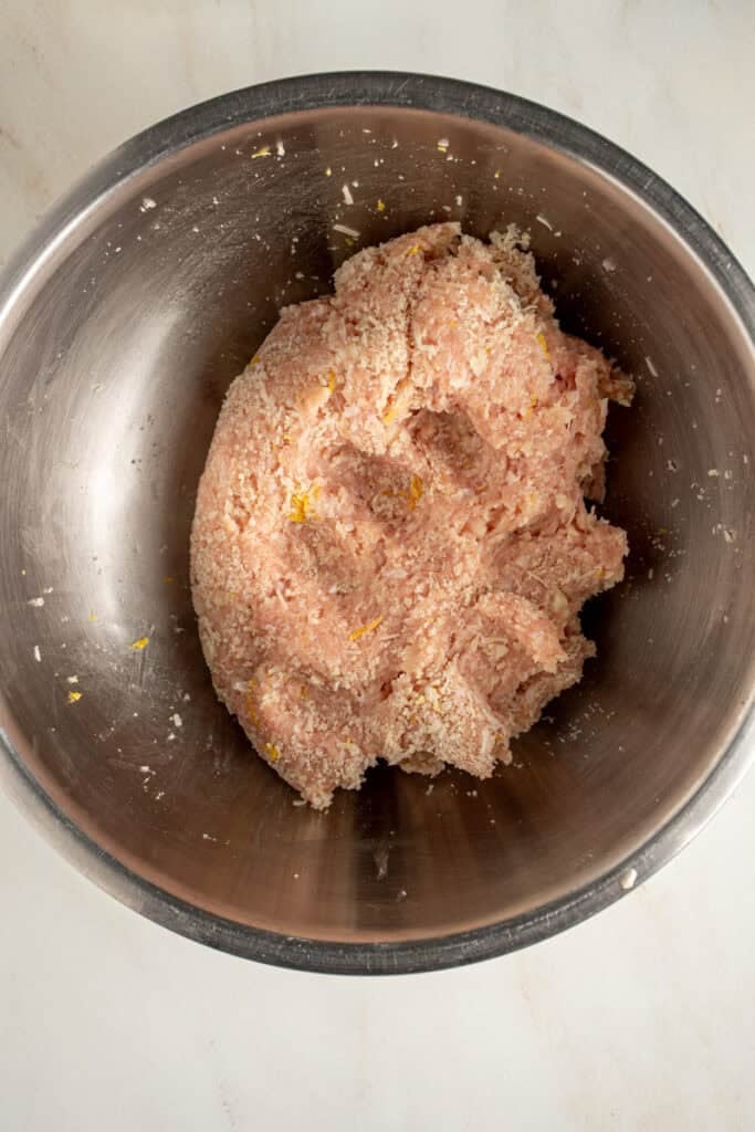 A meatball mixture in a mixing bowl to make chicken piccata meatballs.