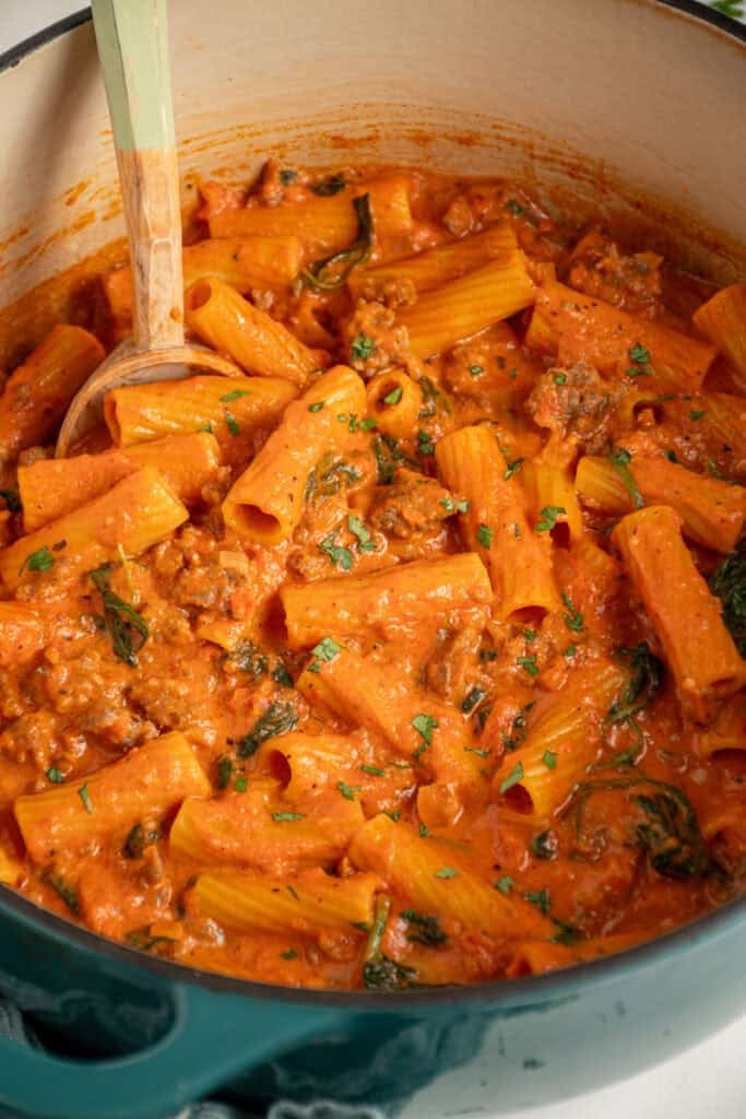 A dutch oven filled with Creamy One Pot Sausage Rigatoni.