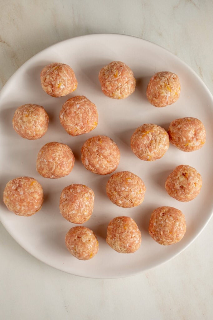 A plate of raw chicken meatballs.