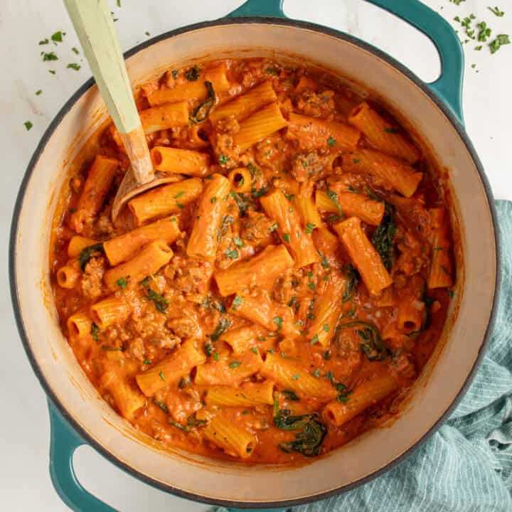 A dutch oven filled with Creamy One Pot Sausage Rigatoni.