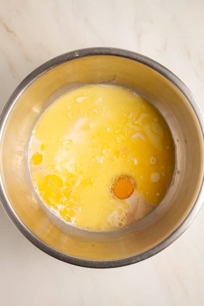 Wet ingredients in a mixing bowl to make apple pancakes.