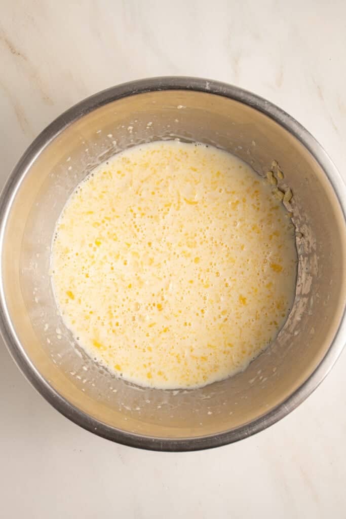 Wet ingredients all mixed together to make pancakes in a mixing bowl.