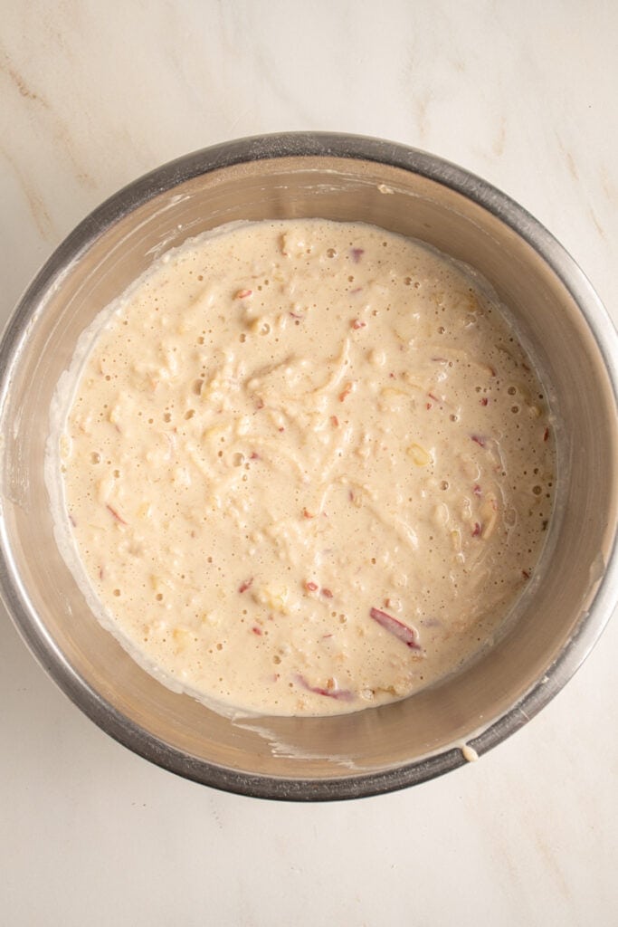 Pancake batter with grated apple mixed in in a bowl.