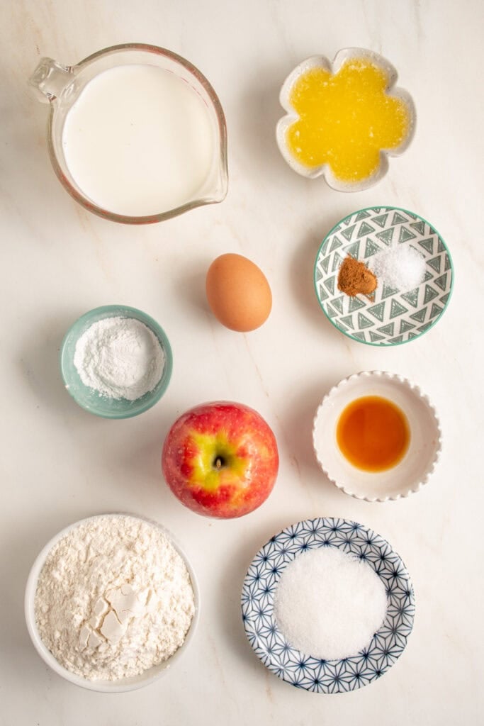 Ingredients needed to make apple pancakes laid out on a tabletop.