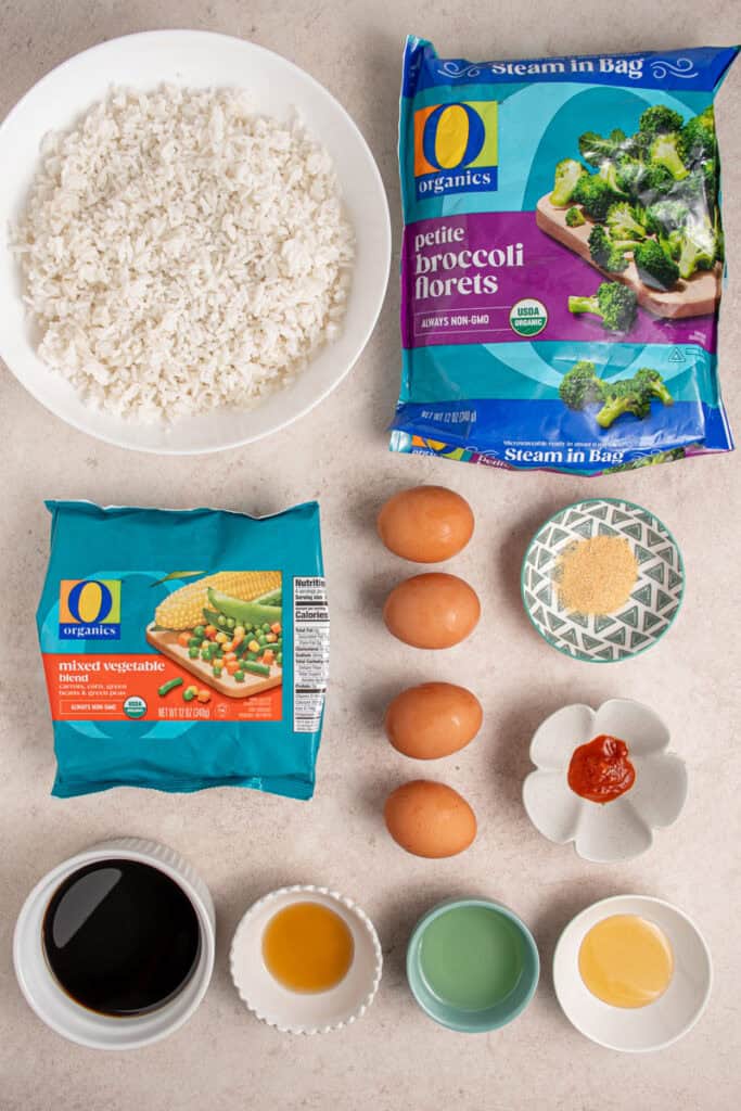 Ingredients for making frozen veggie fried rice laid out on a tabletop.
